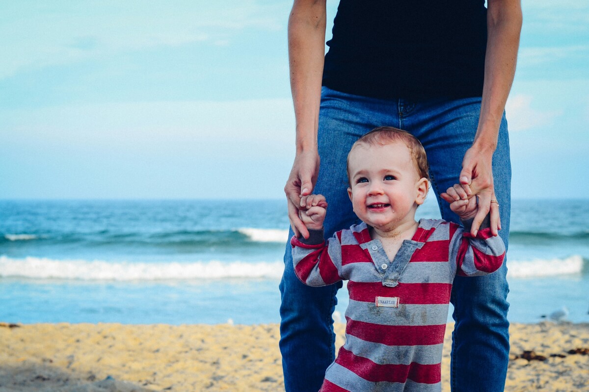 Baby lernt Laufen am Strand